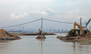 FOTO 1 Nov_Alat berat eskavator melebarkan jalur keluar air (outlet) kolam retensi Terboyo untuk mengurangi genangan banjir di Kota Semarang.