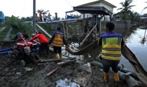 FOTO 13 Des_Sejumlah petugas dari BPBD Kabupaten Langkat, BBWS Sumatra Utara II dan warga berupaya mengoperasikan pompa air untuk menguras genangan