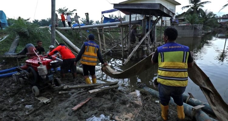 FOTO 13 Des_Sejumlah petugas dari BPBD Kabupaten Langkat, BBWS Sumatra Utara II dan warga berupaya mengoperasikan pompa air untuk menguras genangan