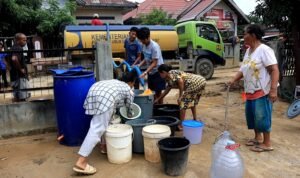 FOTO 21 Des_Warga menerima air bersih yang didistribusikan pemerintah daerah melalui hidran umum di Kecamatan Sarudik, Tapanuli Tengah.
