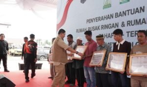 FOTO 22 Juni_Kepala Badan Nasional Penanggulangan Bencana (BNPB) Letjen TNI Suharyanto menyerahkan kepada perwakilan masyarakat penerima bantuan perbaikan rumah